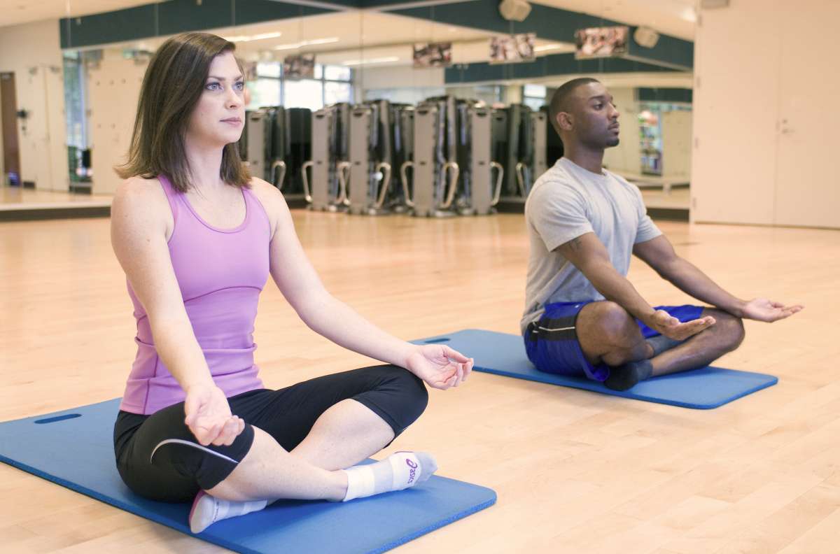 A man and woman practicing yoga in a fitness center